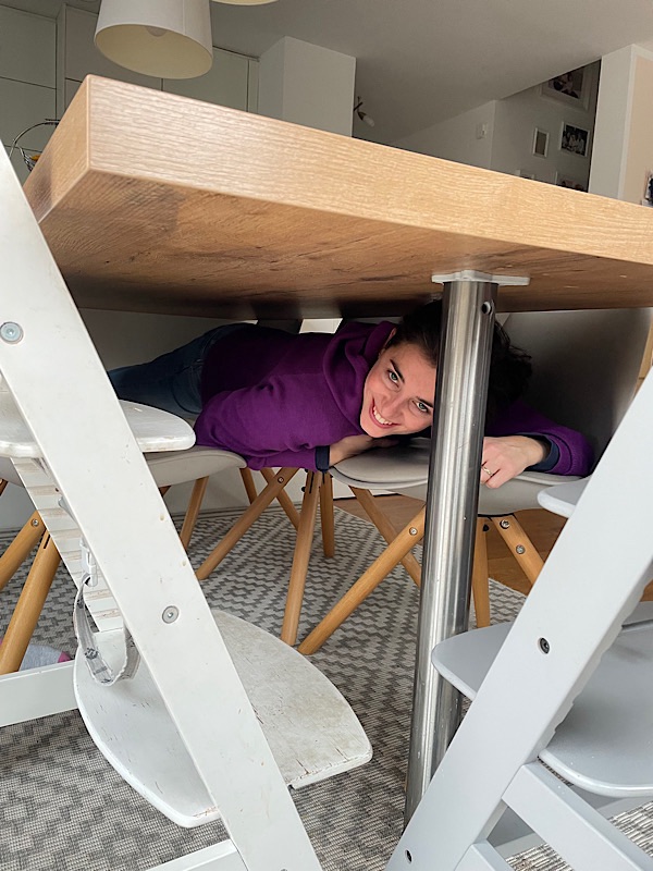 Frau versteckt unter dem Tisch
