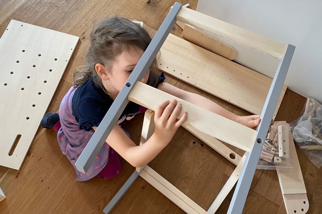 Mädchen steckt Holzbretter zusammen