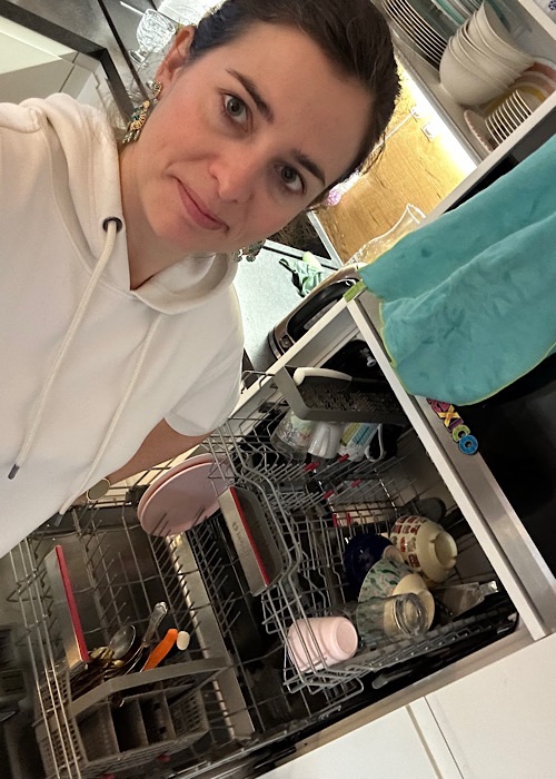 Frau vor dem Geschirrspüler